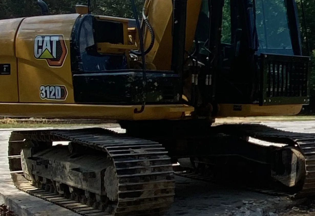 Tracked excavator standing on a broken-up concrete slab during a slab removal in north Louisiana