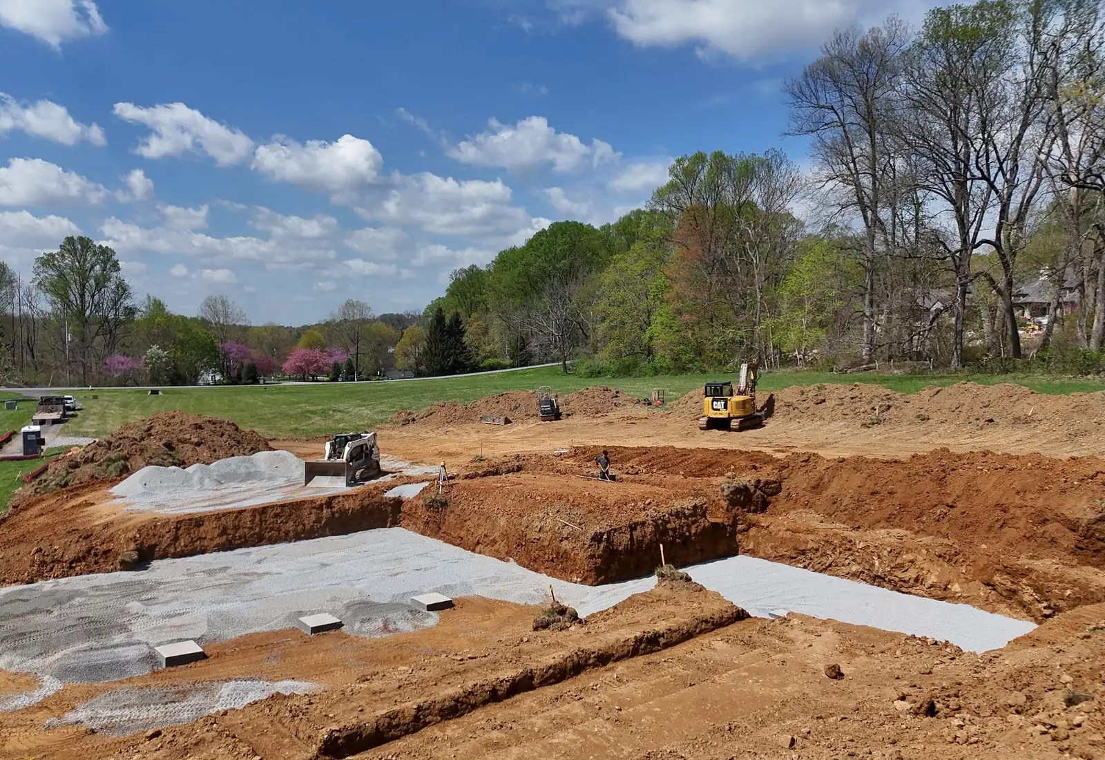 Dug footings and gravel pads on a residential building site with spoil piles alongside